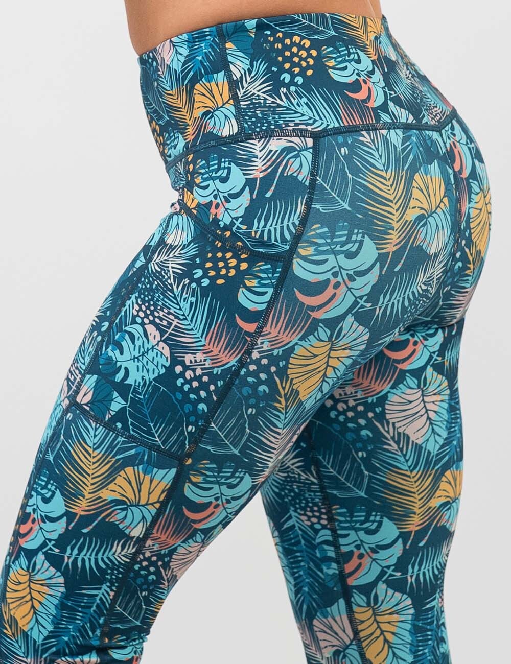 back of the blue, pink, yellow, and red tropical leaves leggings against a white background