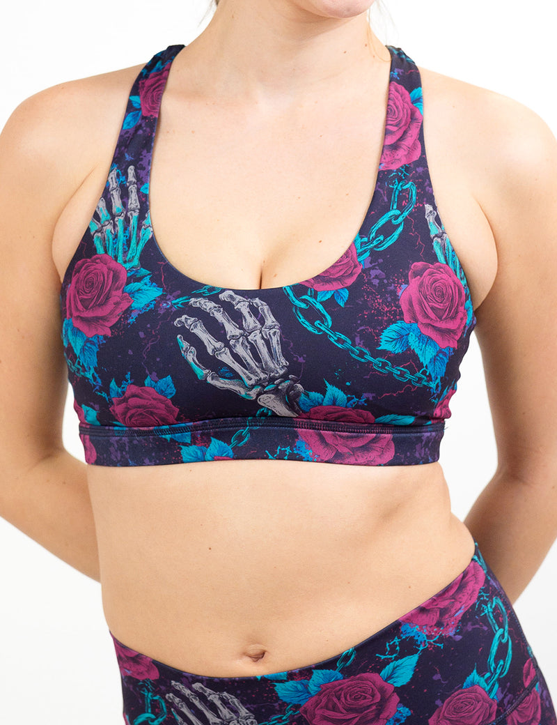 front of the roses and skeleton hands connected by chain links pattern bra against a white background