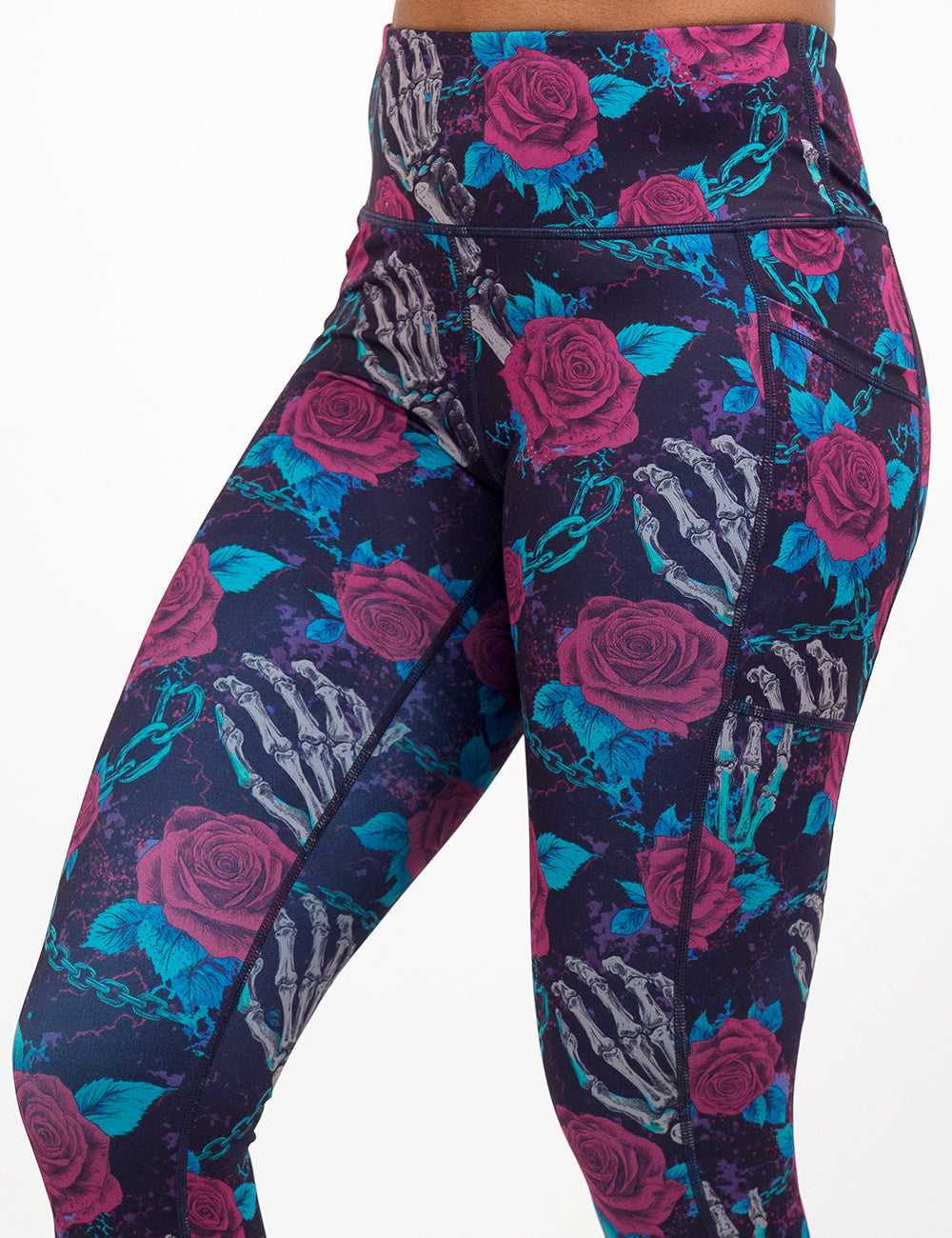 close up of the roses and skeleton hands connected by chain links pattern leggings against a white background