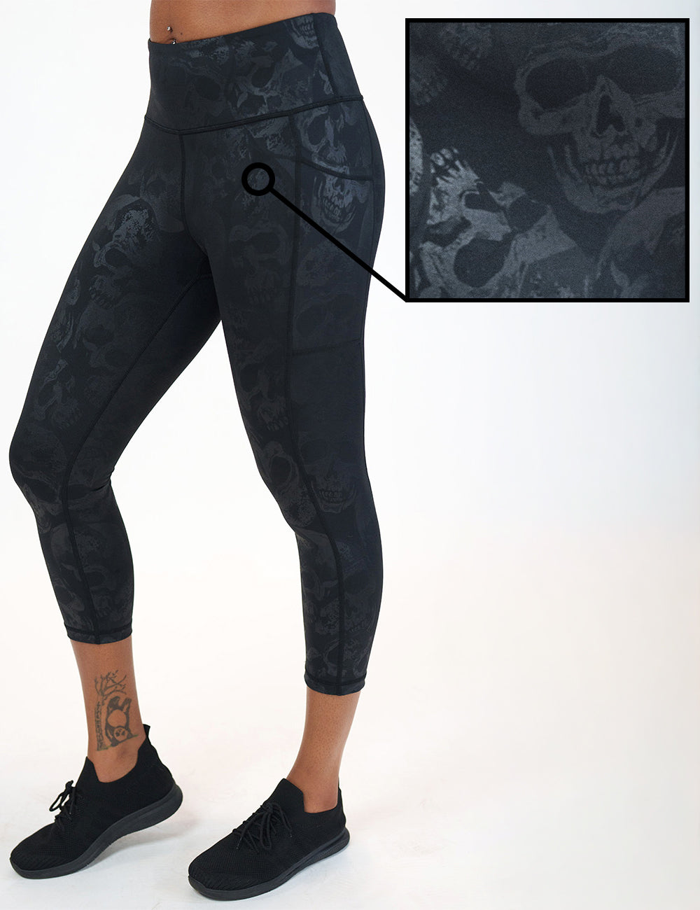 front of the black capri leggings with a dark grey skull pattern against a white background