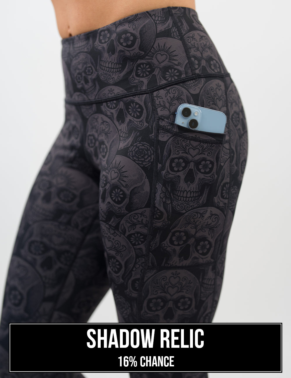 side view of the dark grey calavera skulls against a black background leggings with a phone in its pocket, the name of this print is shadow relic and it has a 16% chance of being unboxed