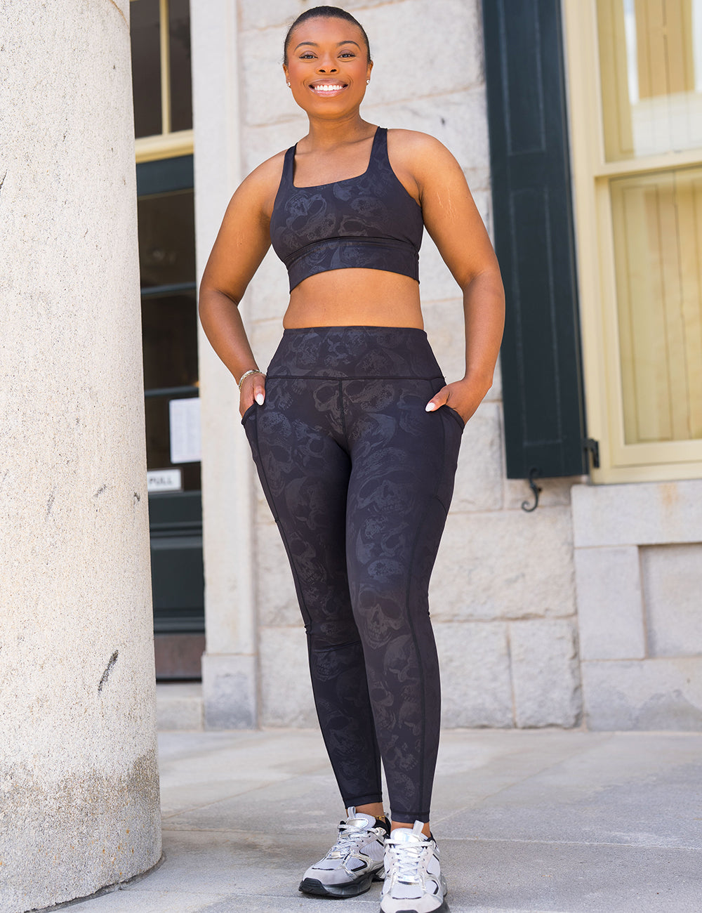 model wearing the full length black leggings with a dark grey skull pattern