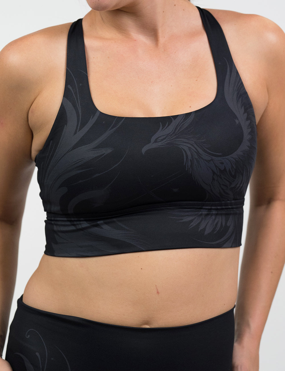 front of the black bra with a phoenix design on it against a white background