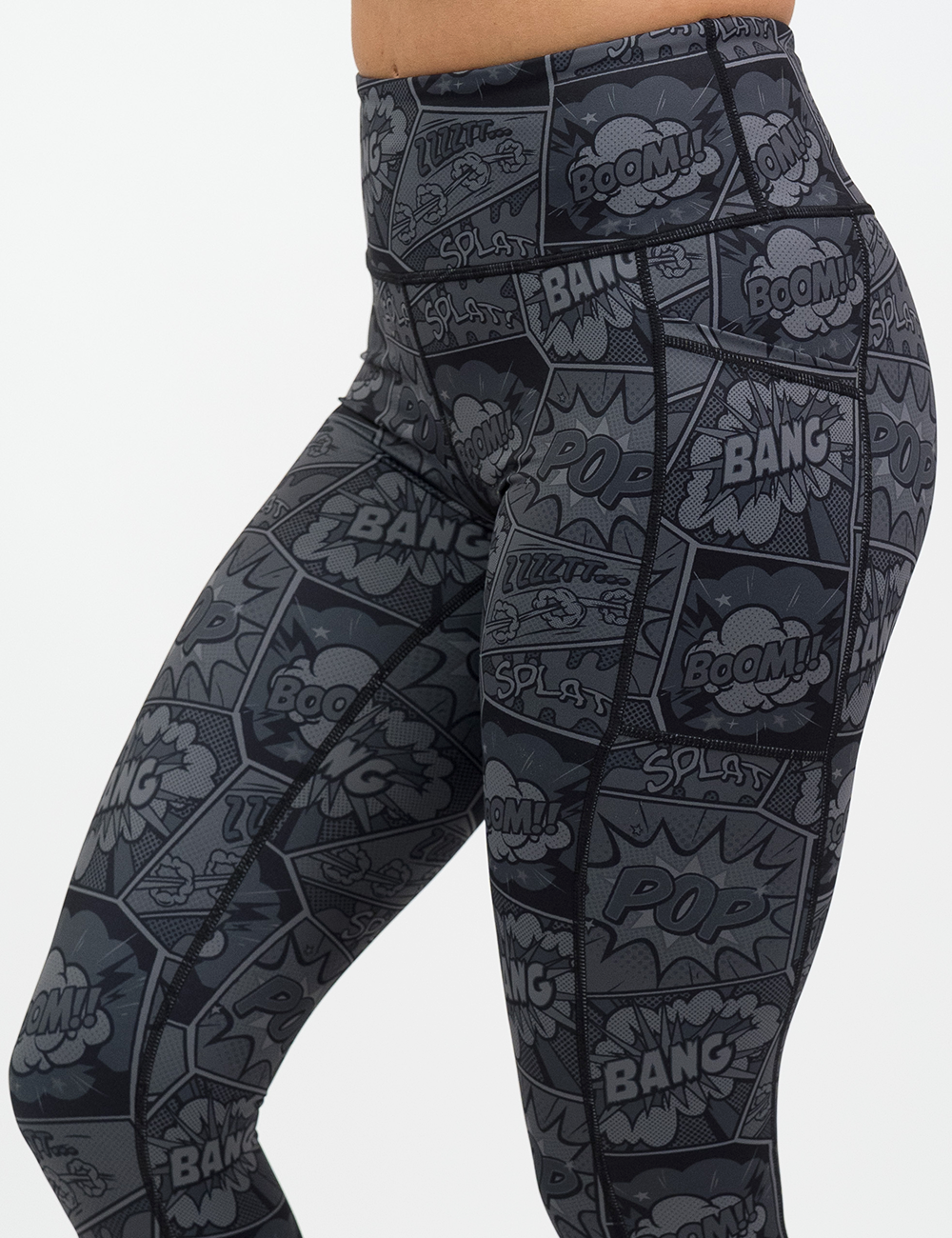 close up of the black and grey comic book print leggings with a phone in the pocket