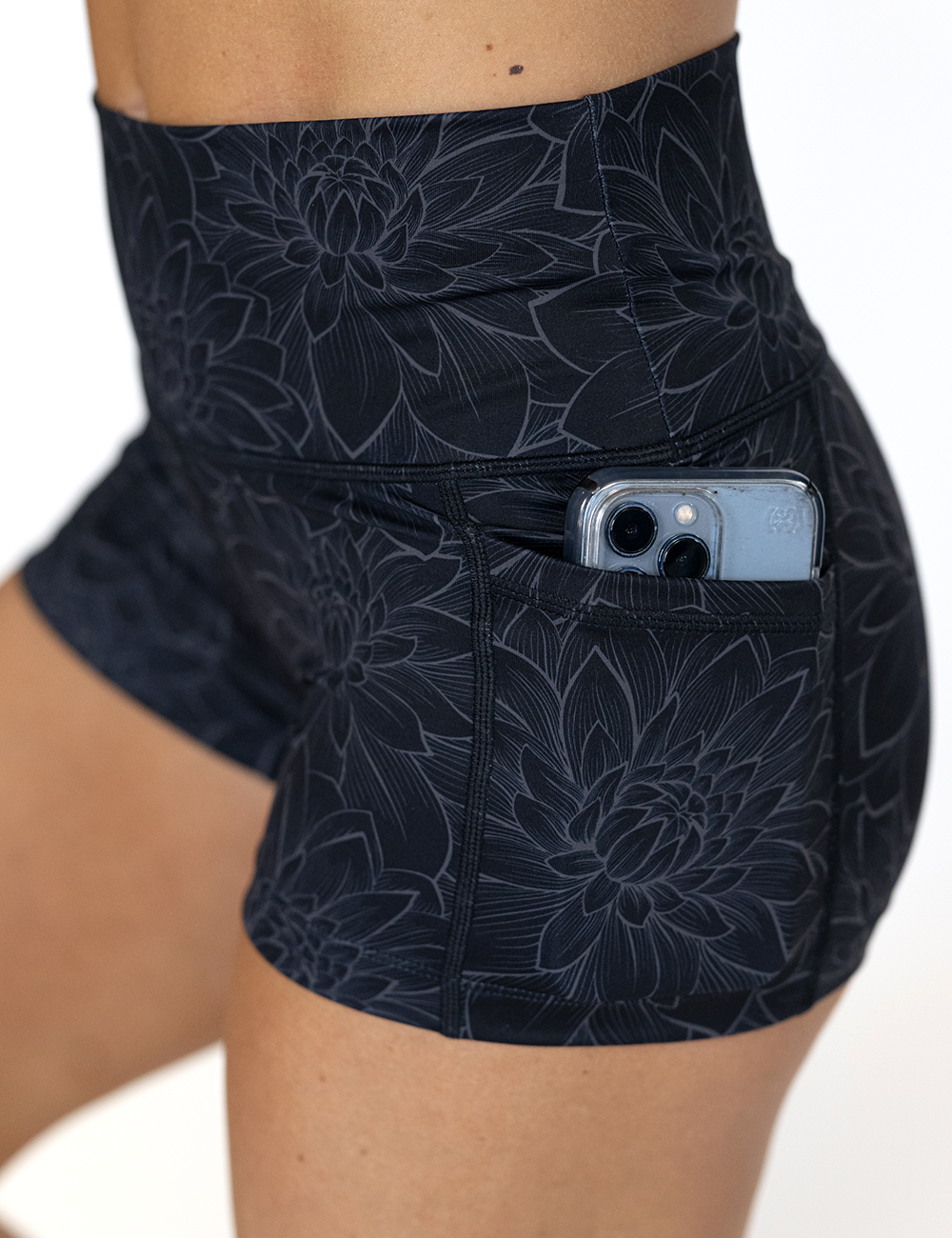 close up of the etched lotus flower against a black background showing the pocket with a phone in it