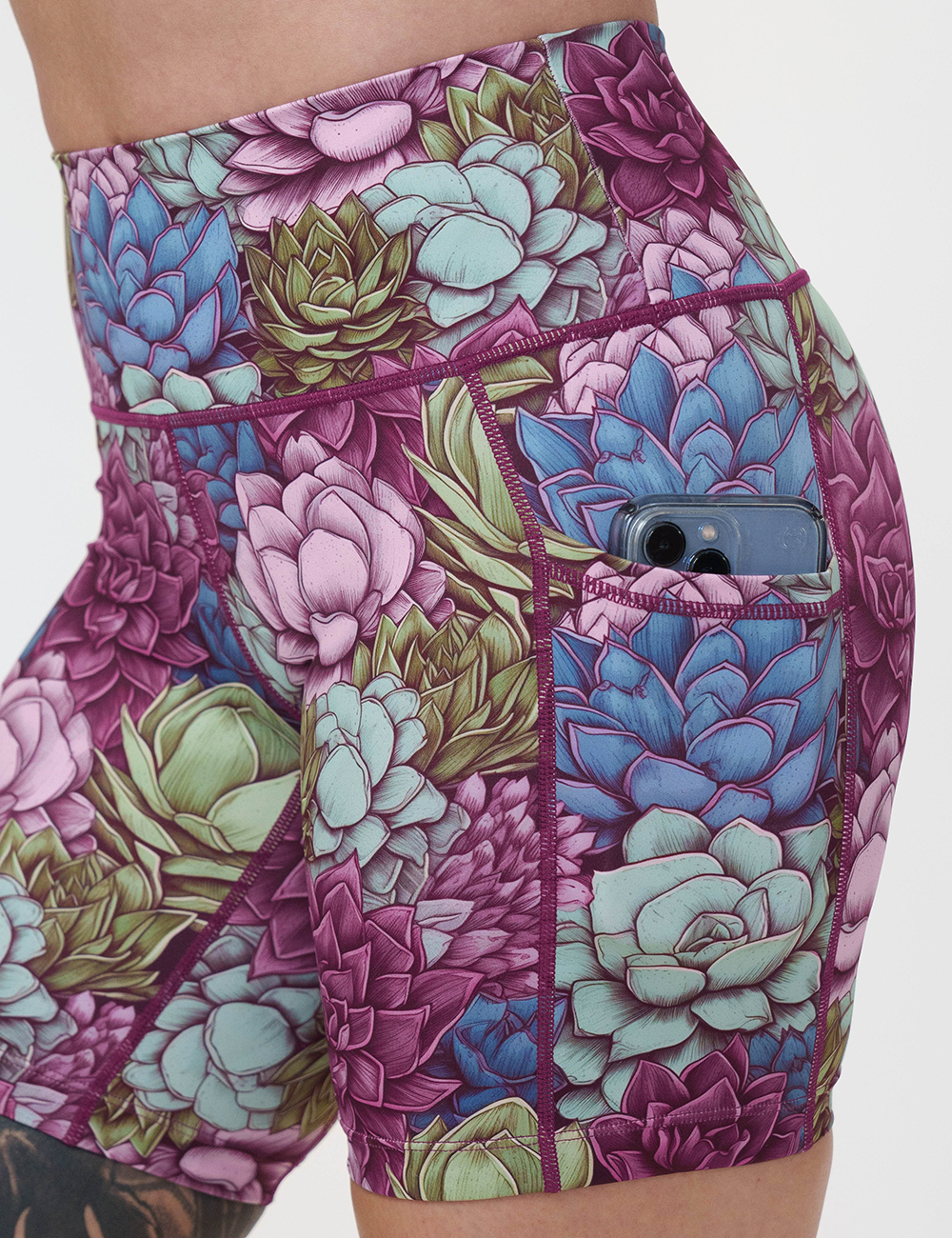 close up of the succulents and plants shorts pocket with a phone in it against a white background