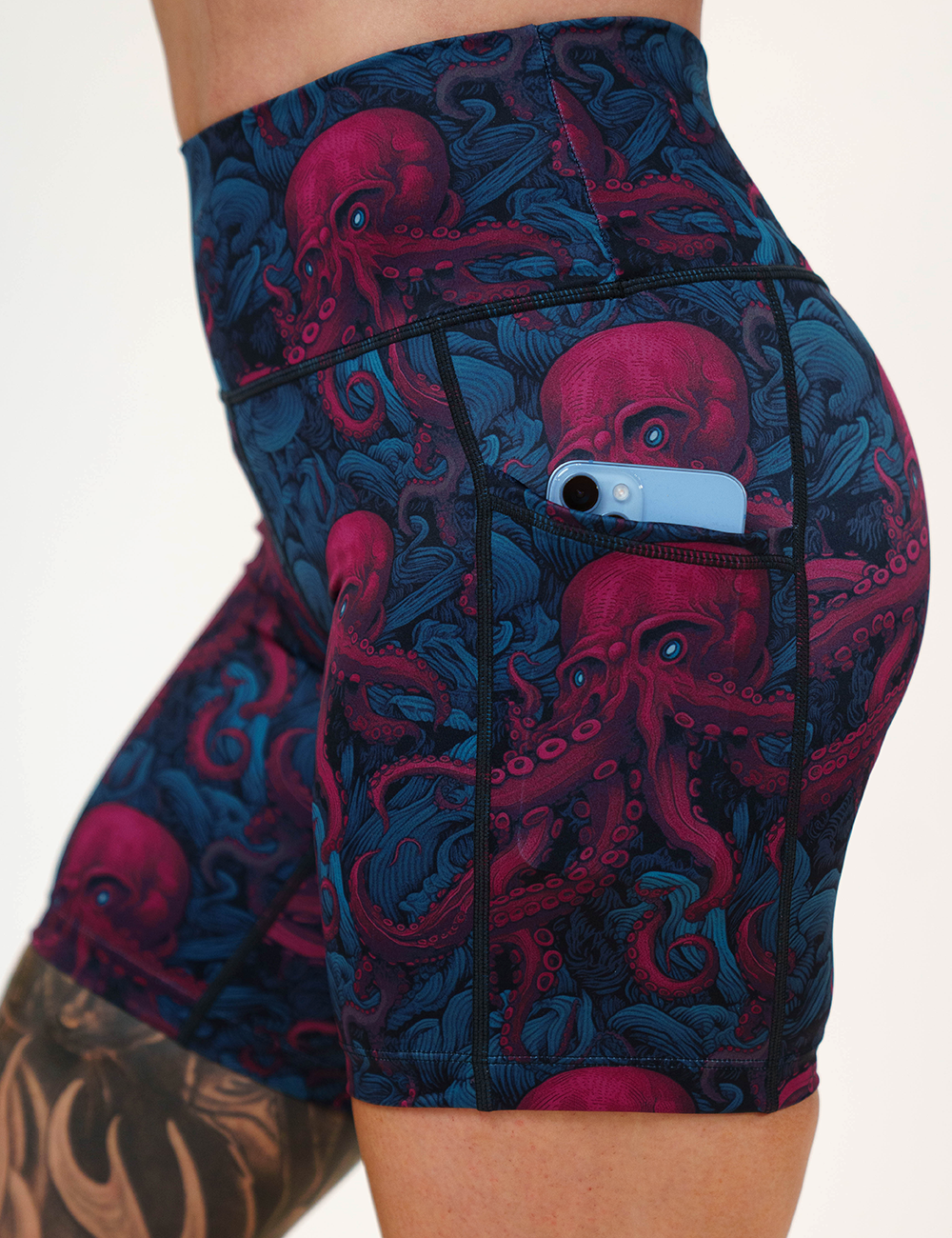 close up of the maroon octopus with blue eyes showing the pocket with a phone in it against a white background