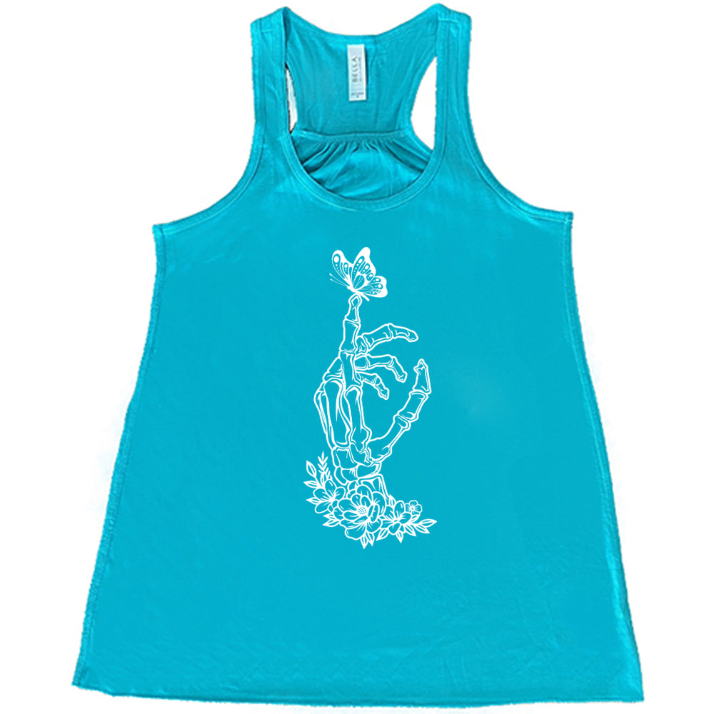 Teal colored flowy tank with a butterfly on a skeletons hand graphic on it