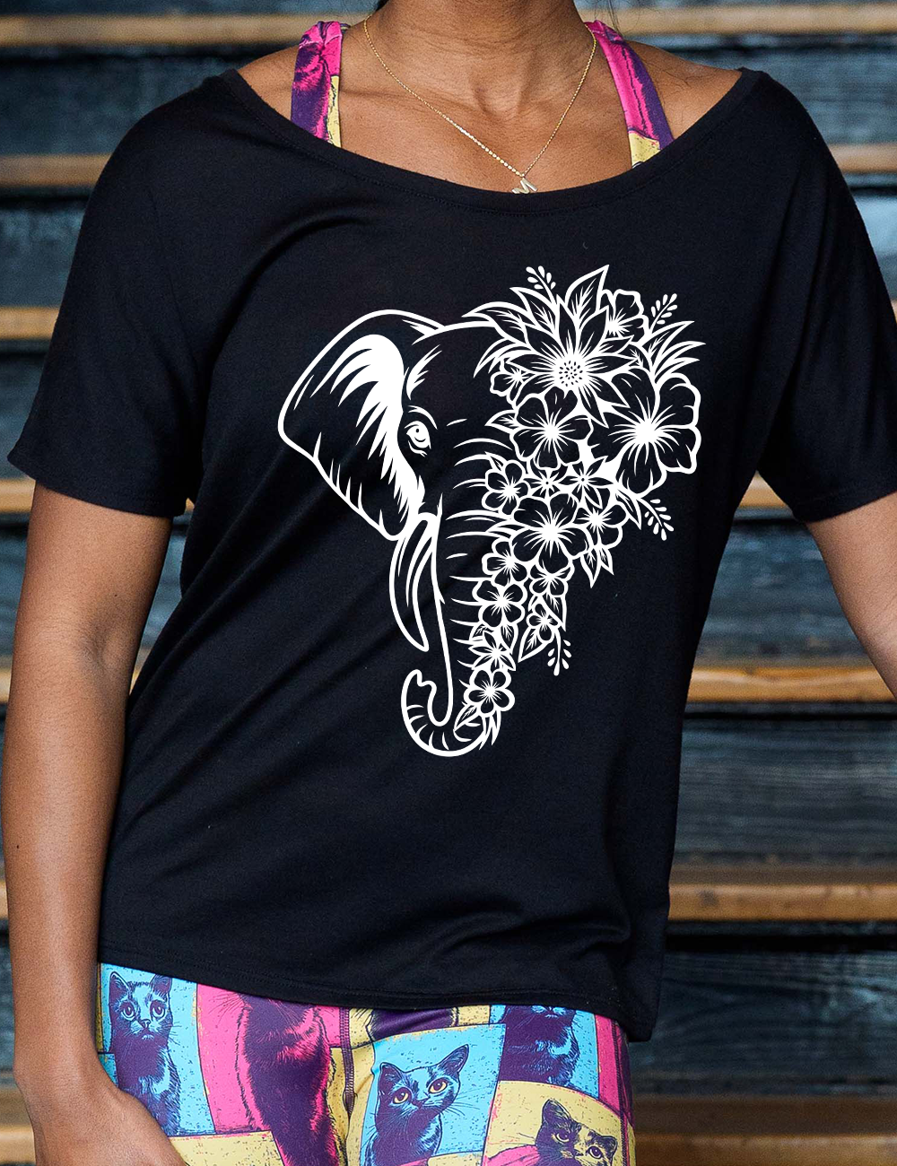 black slouchy tee with the graphic of an elephant's head, with half of its head made up only of tropical flowers