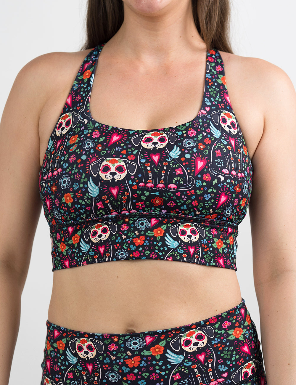 front of the skeleton dogs surrounded by flowers bra against a white background