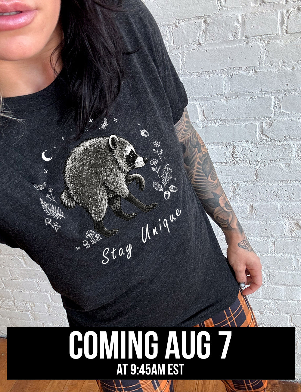 front of the black "stay unique" raccoon unisex tee , coming soon