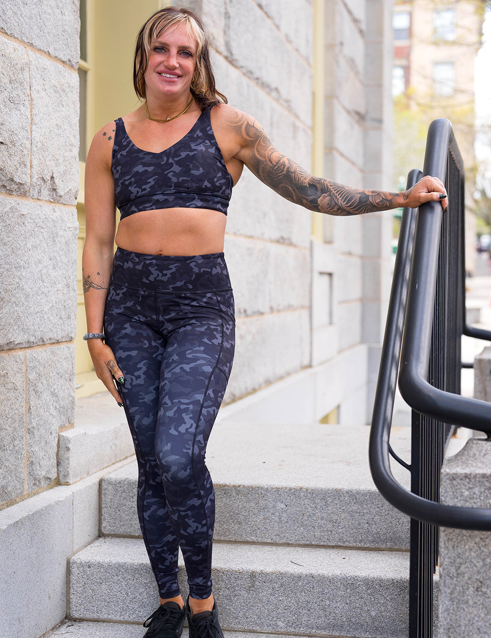 model wearing the full length black camo print leggings and sports bra
