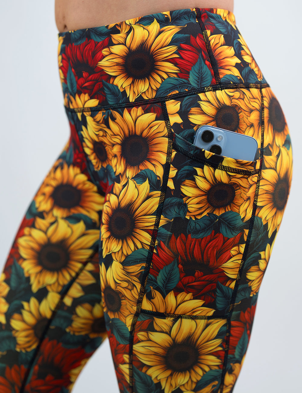 close up of the sunflower with red flowers leggings with a phone in its pocket