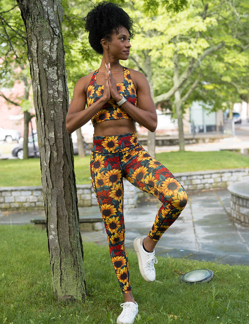 model wearing the sunflower with red flowers full length leggings doing yoga