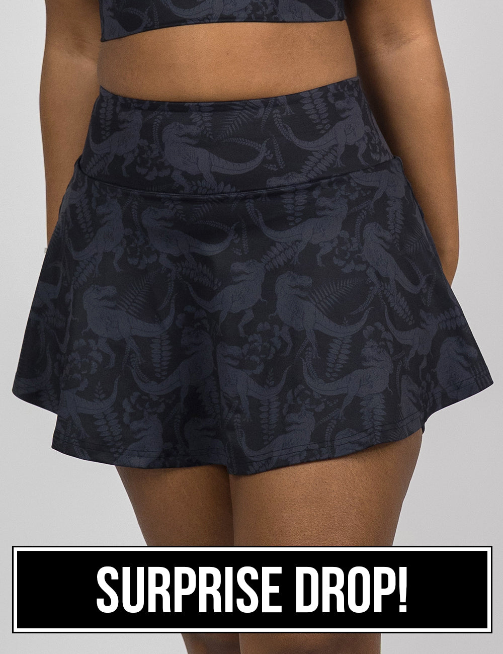 front of the black regular length skirt with a dark grey t-rex pattern against a white background, surprise drop