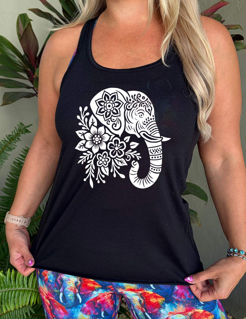 black racerback tank with the large graphic of the profile of an elephant's head, with flowers for a torso, and patterns lining its truck and flowers patterned into its ear and forehead