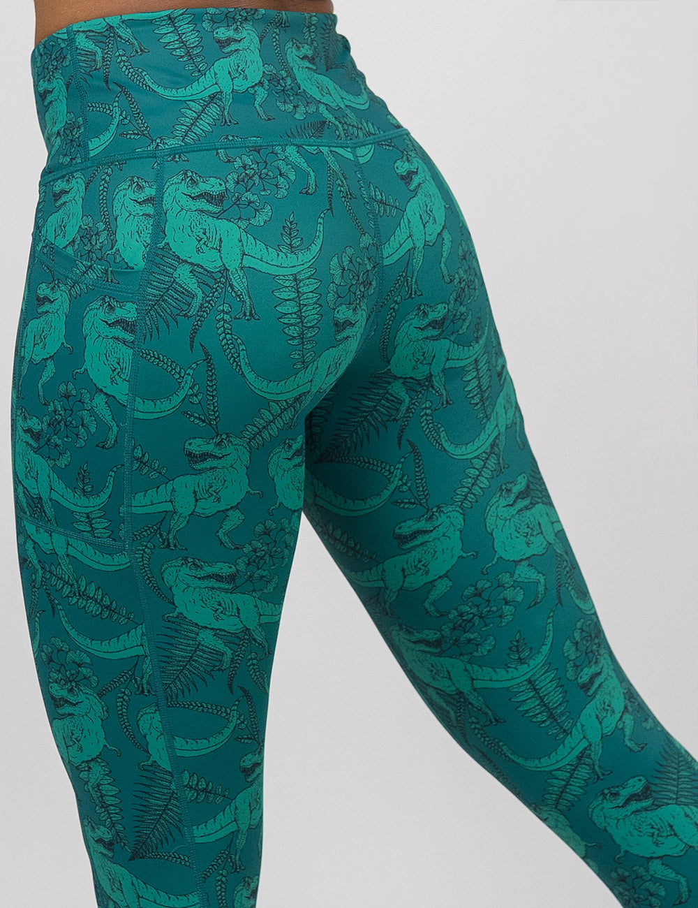 back of the teal t-rex pattern leggings against a white background