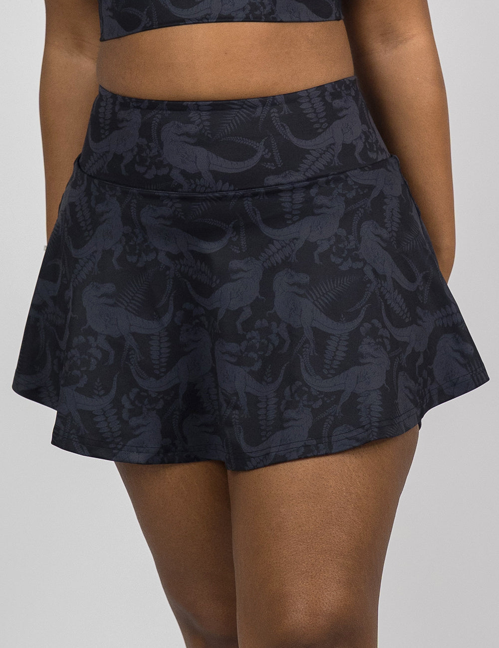front of the black regular length skirt with a dark grey t-rex pattern against a white background