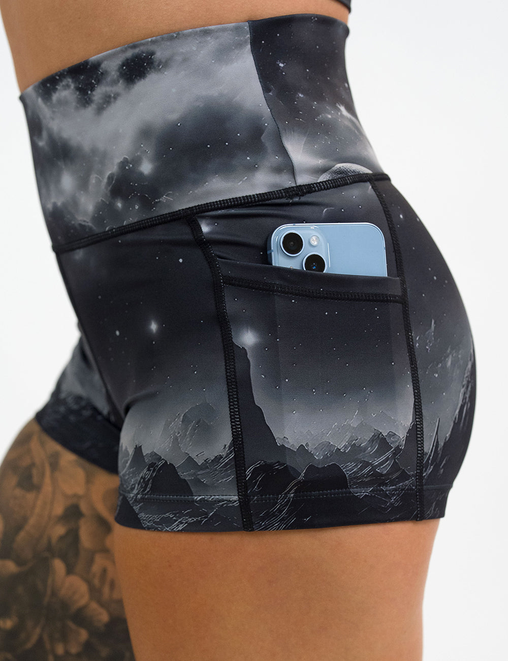 close up of the 2.5 inch dark mountains in space shorts with a phone in its pocket