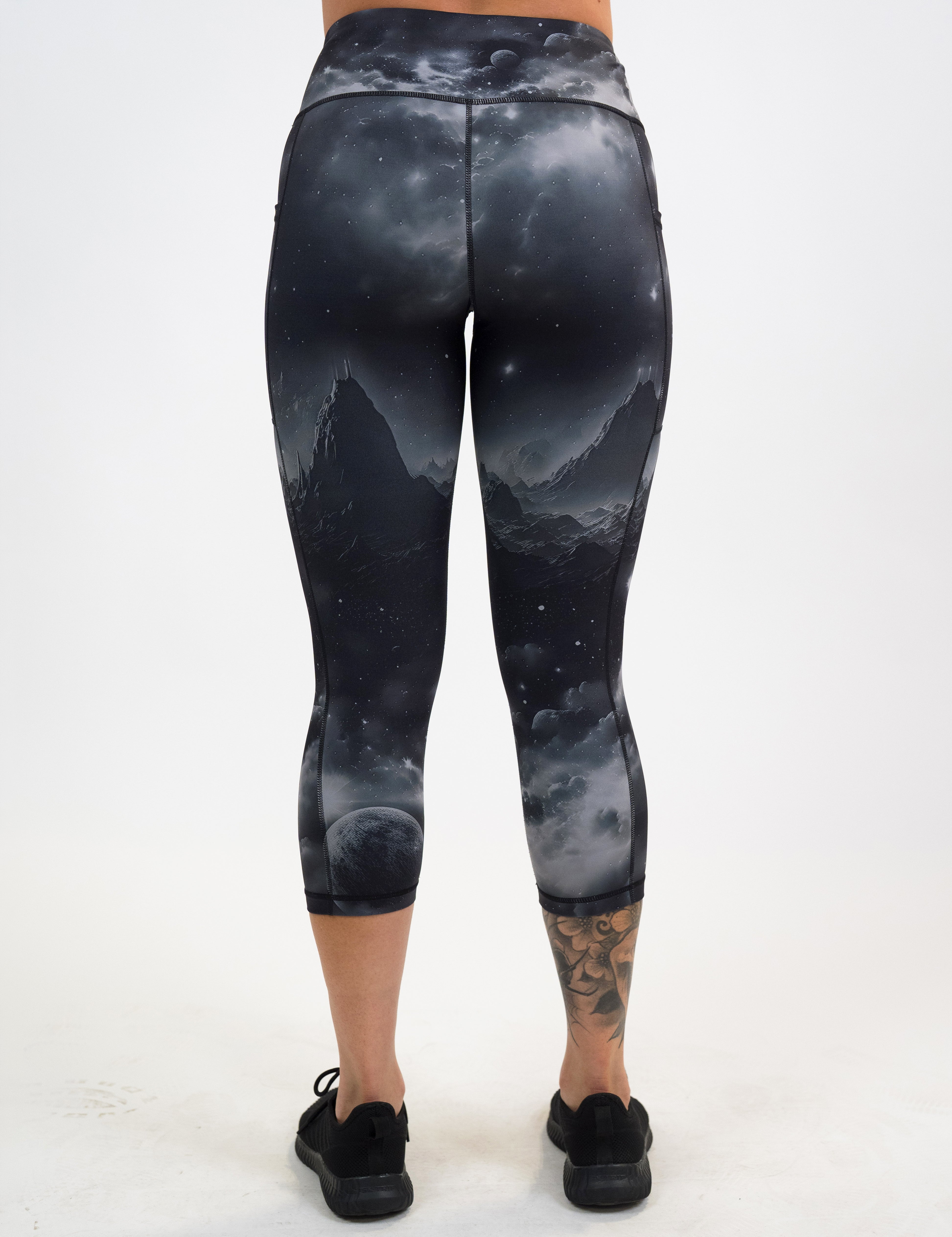 back of the capri black leggings with mountain and star pattern against a white background