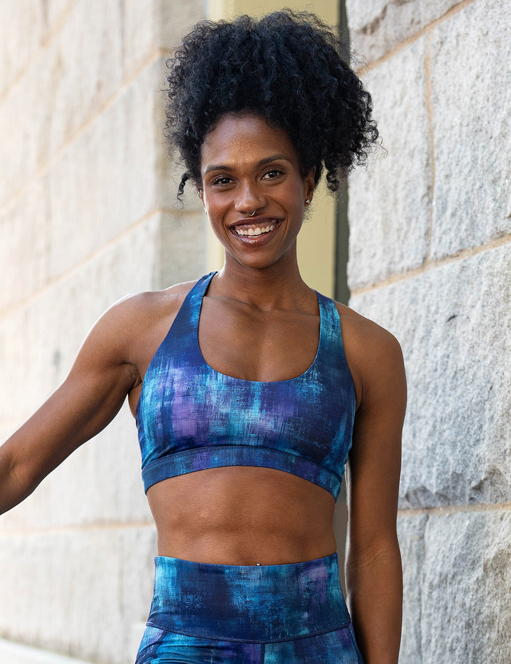 model wearing the blue, teal, and purple grunge concrete pattern bra and leggings
