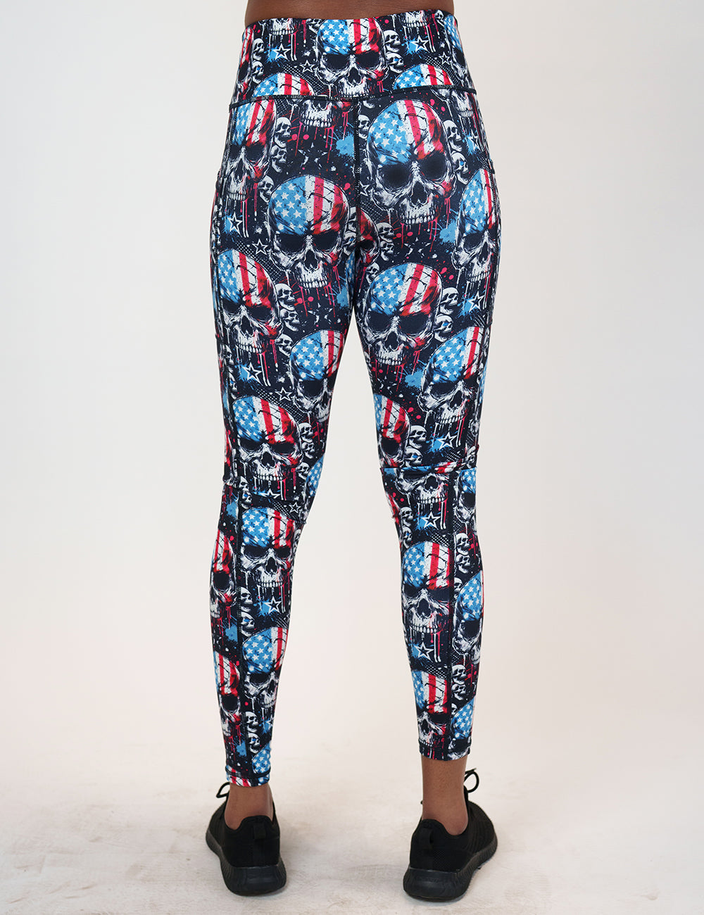 back of the full length black leggings with american flag skulls against a white background