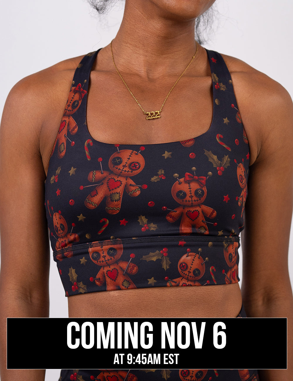 front of the gingerbread voodoo dolls with pins in them surrounded by berries and stars on a black background sports bra coming November 6th