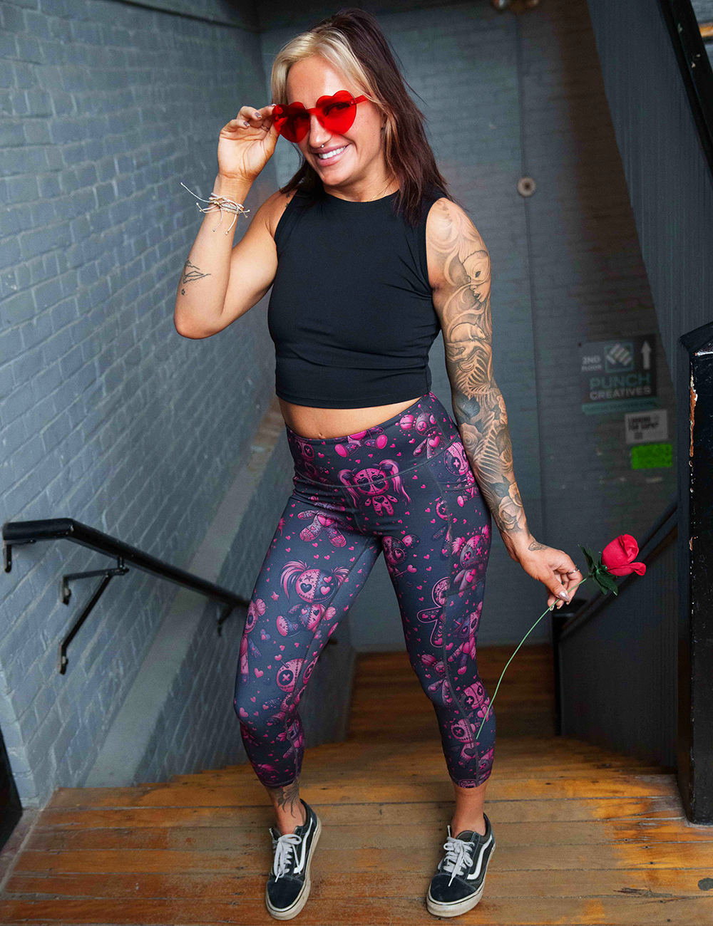 pink voodoo doll with pink hearts pattern full length leggings in a stairwell