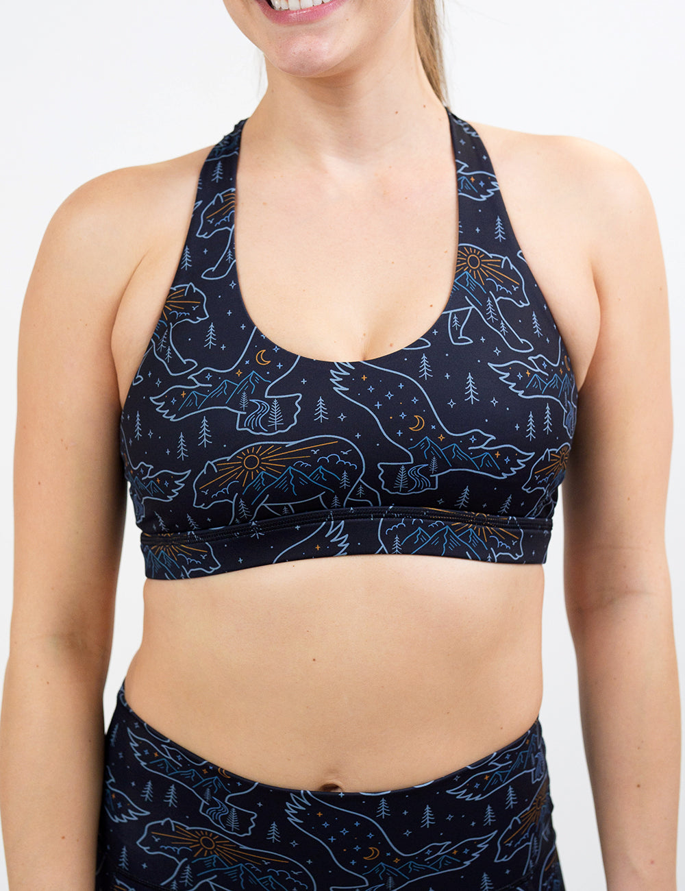 front of the bird and bear outlines against a dark background butterfly back bra against a white background