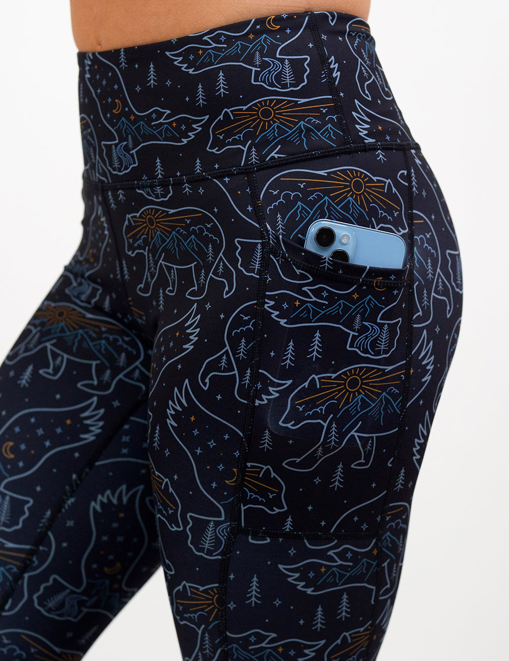 close up of the bird and bear outlines leggings with a phone in its pocket