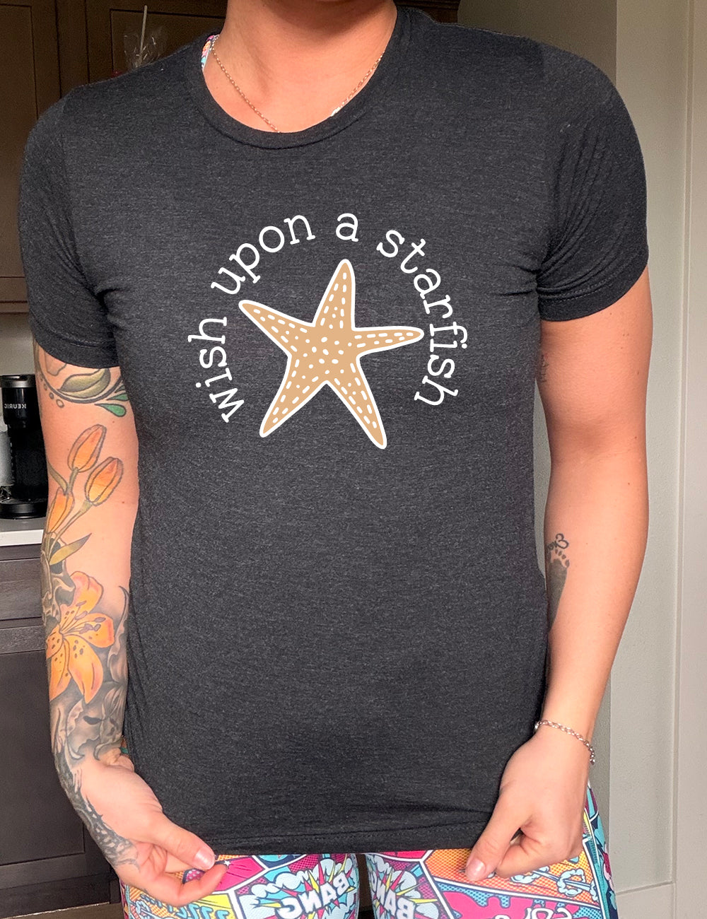black unisex tee with the graphic of a starfish, and the words arched around it saying "wish upon a starfish"