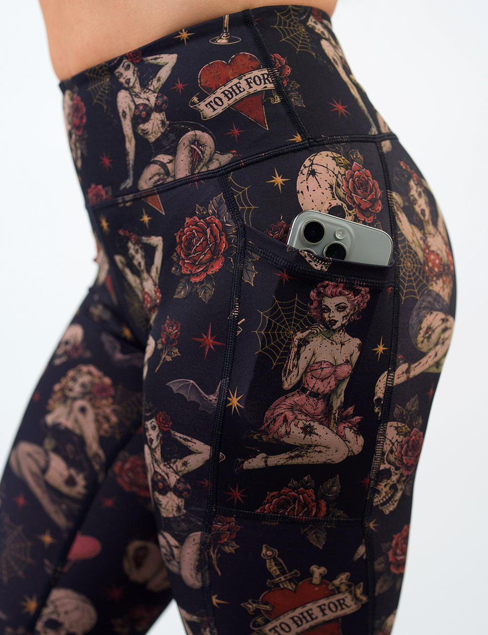 side of the zombie girls with pin up hair and traditional tattoo design leggings with a phone in its pocket against a white background