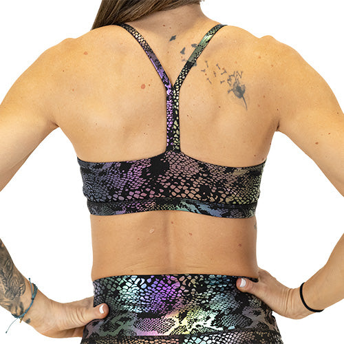 back view of black, purple and green holographic sports bra