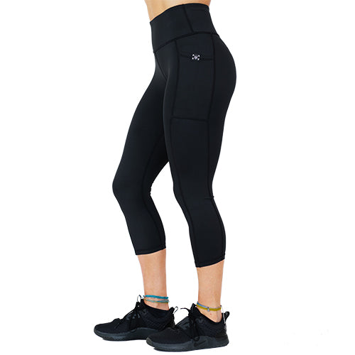 side view of capri length solid black leggings with mini skull and barbells logo on side pocket