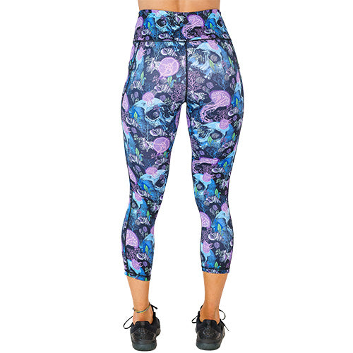 back view of capri length purple jelly fish and blue skull print leggings