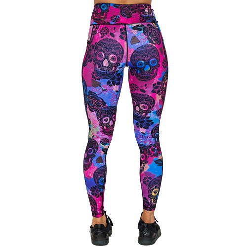 back view of full length purple, pink and blue tie dye leggings with black skull and rose pattern