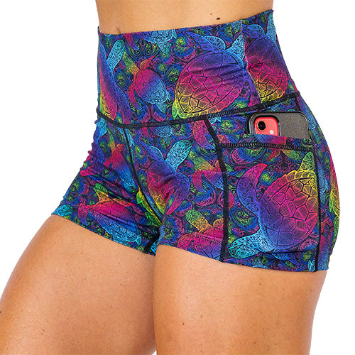 close up of side pocket that is large enough to hold a cell phone on the pink, yellow, blue, green and purple ombre turtle print 2.5 inch shorts against a white background