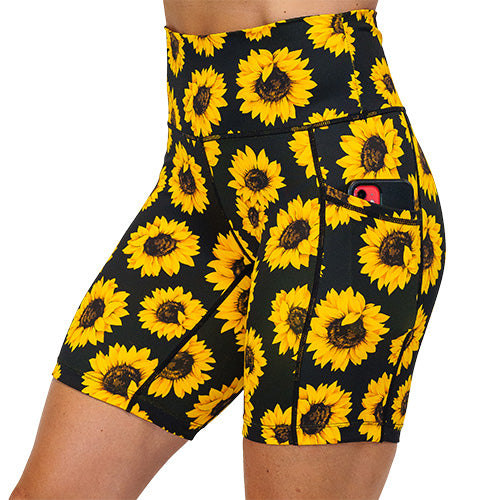 close up of side pocket that can hold a cell phone on the yellow flower shorts against a white background