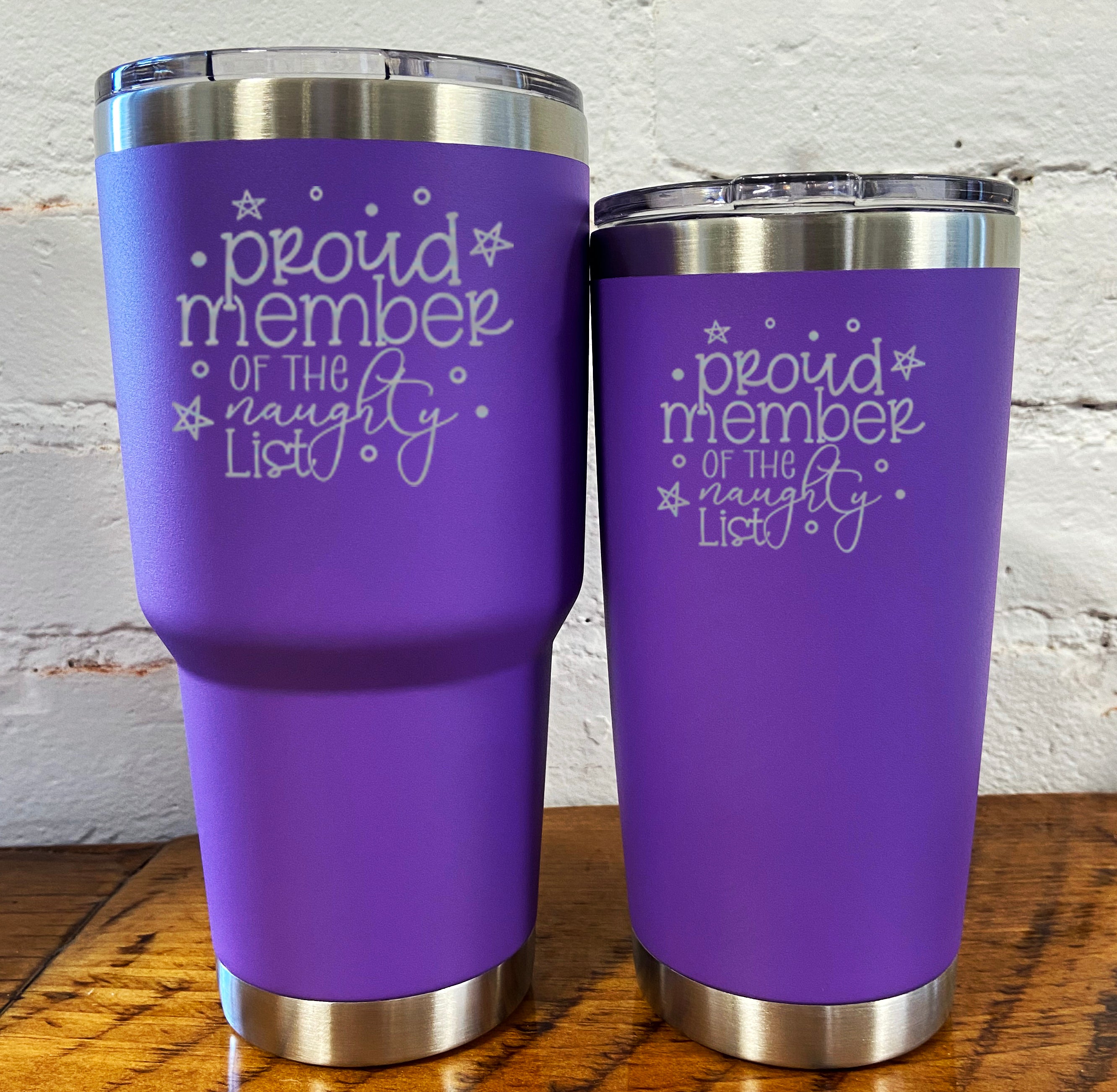 30oz and 20oz purple tumblers with silver saying "proud member of the naughty list"