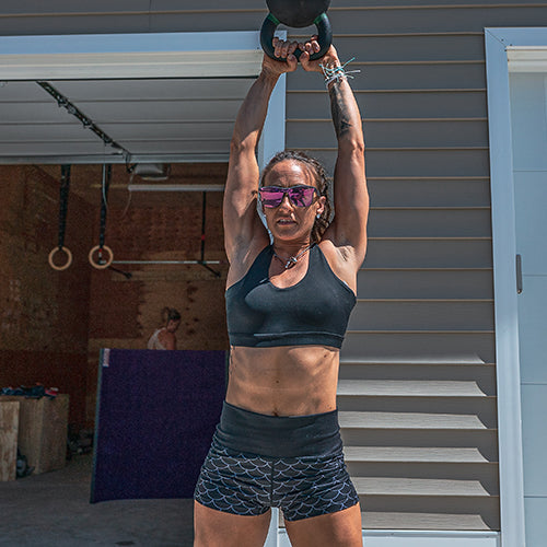model wearing solid black sports bra and dragon scale shorts