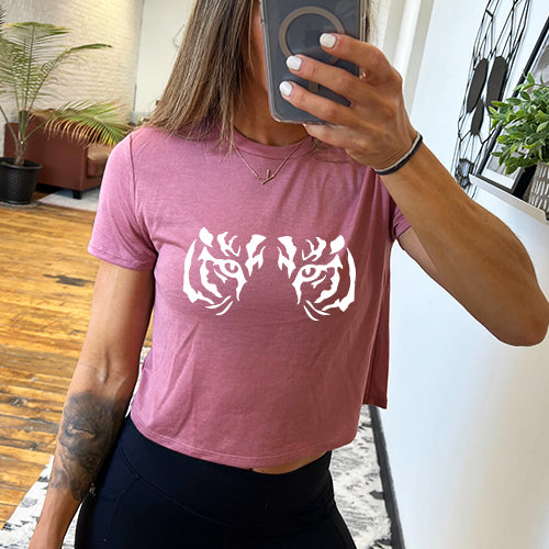 Model wearing a mauve colored cropped tee with tiger eyes on the front
