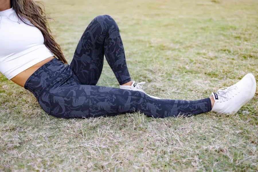 A woman wearing leggings sits in the grass