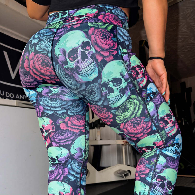 Colorful leggings with skull and floral pattern worn by a person.