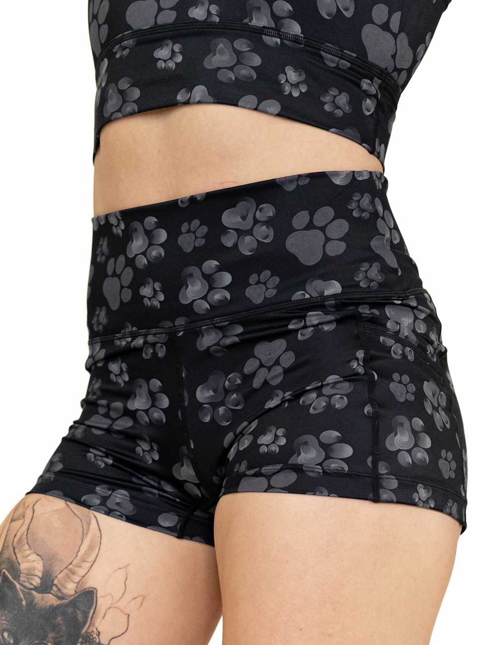 close up of the 2.5 inch grey paw prints against a black background shorts
