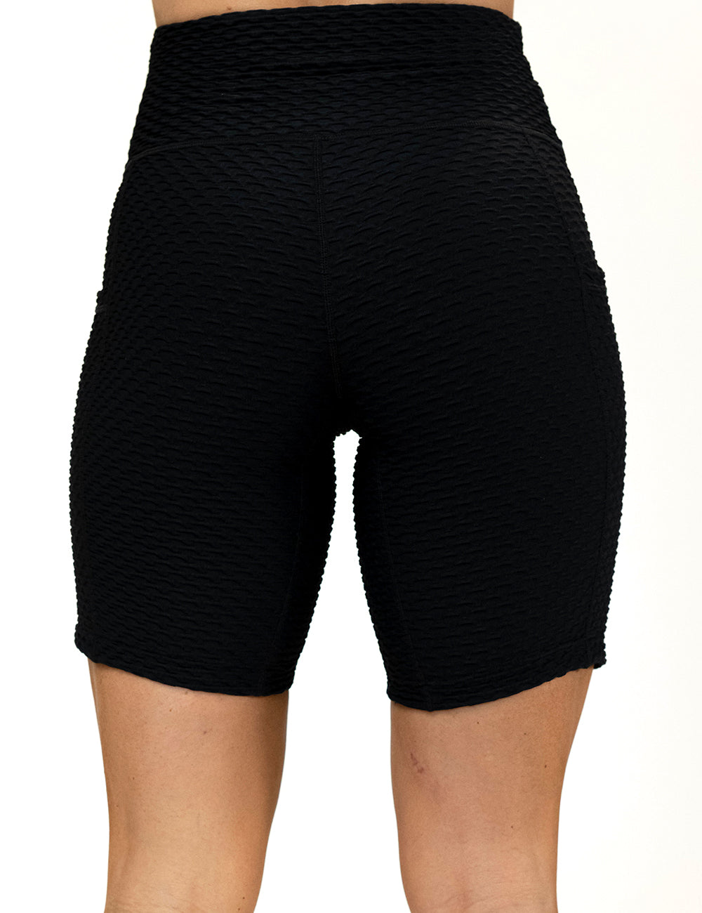 back of the 7 inch black waffled texture shorts against a white background