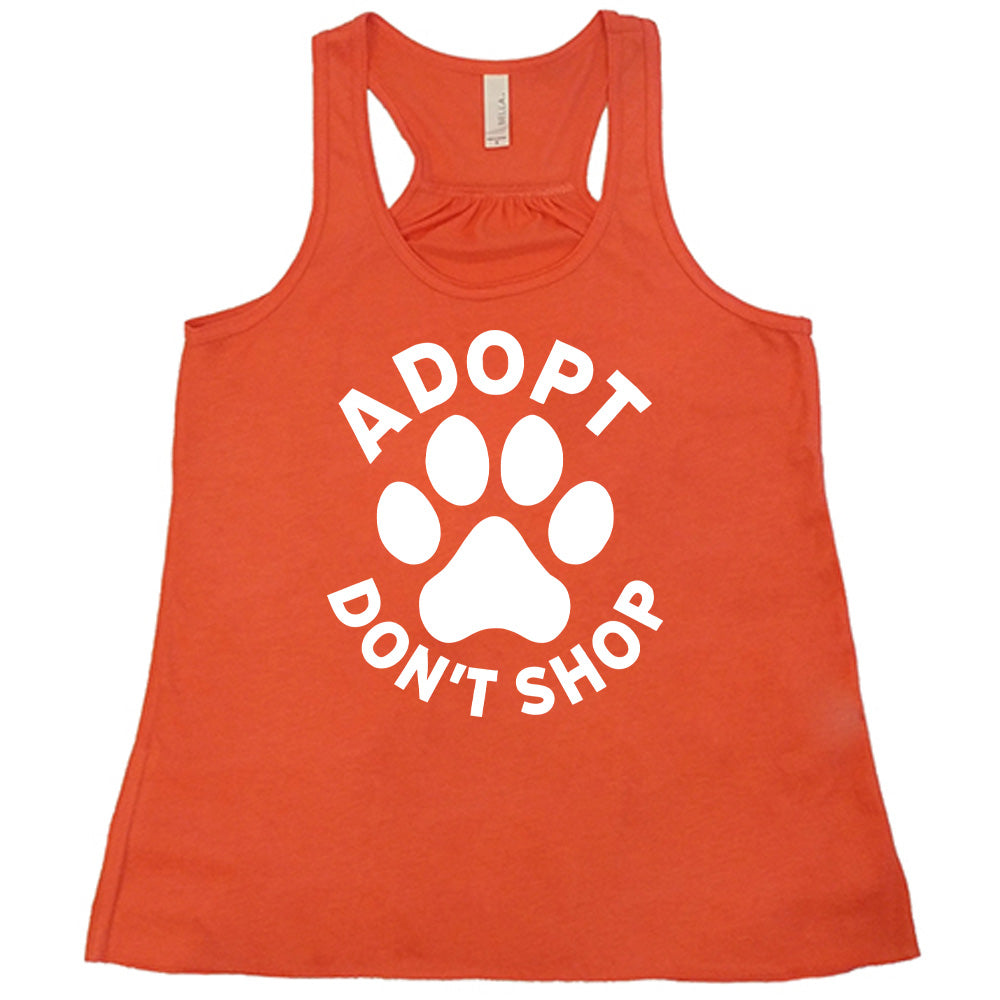 Coral colored flowy tank with paw print graphic on it that says "Adopt Don't Shop"
