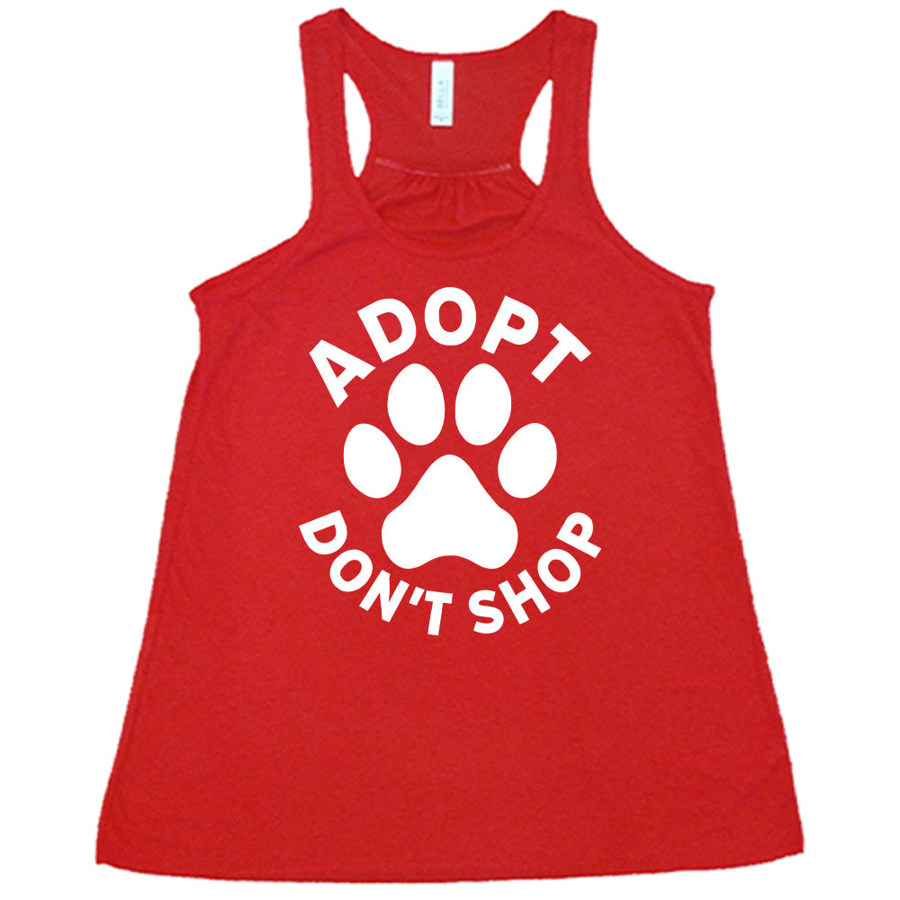 Red colored flowy tank with paw print graphic on it that says "Adopt Don't Shop"