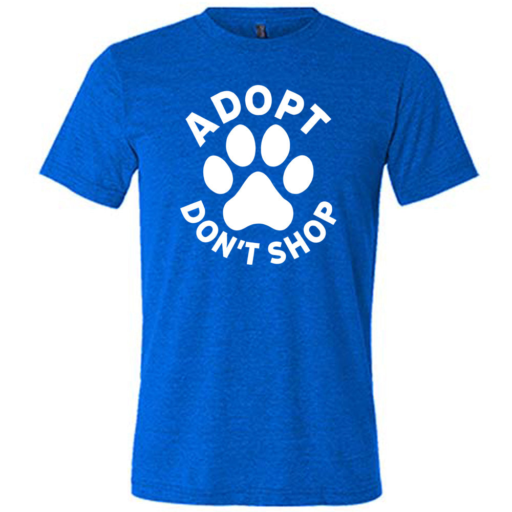 Blue colored shirt with paw print graphic on it that says "Adopt Don't Shop"