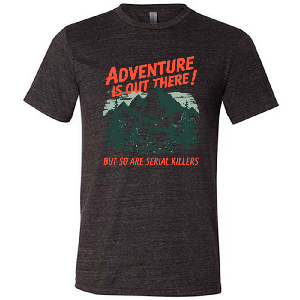 black unisex tee with the words "adventure is out there! but so are serial killers" on it, with the graphic of mountains and woods and birds flying 