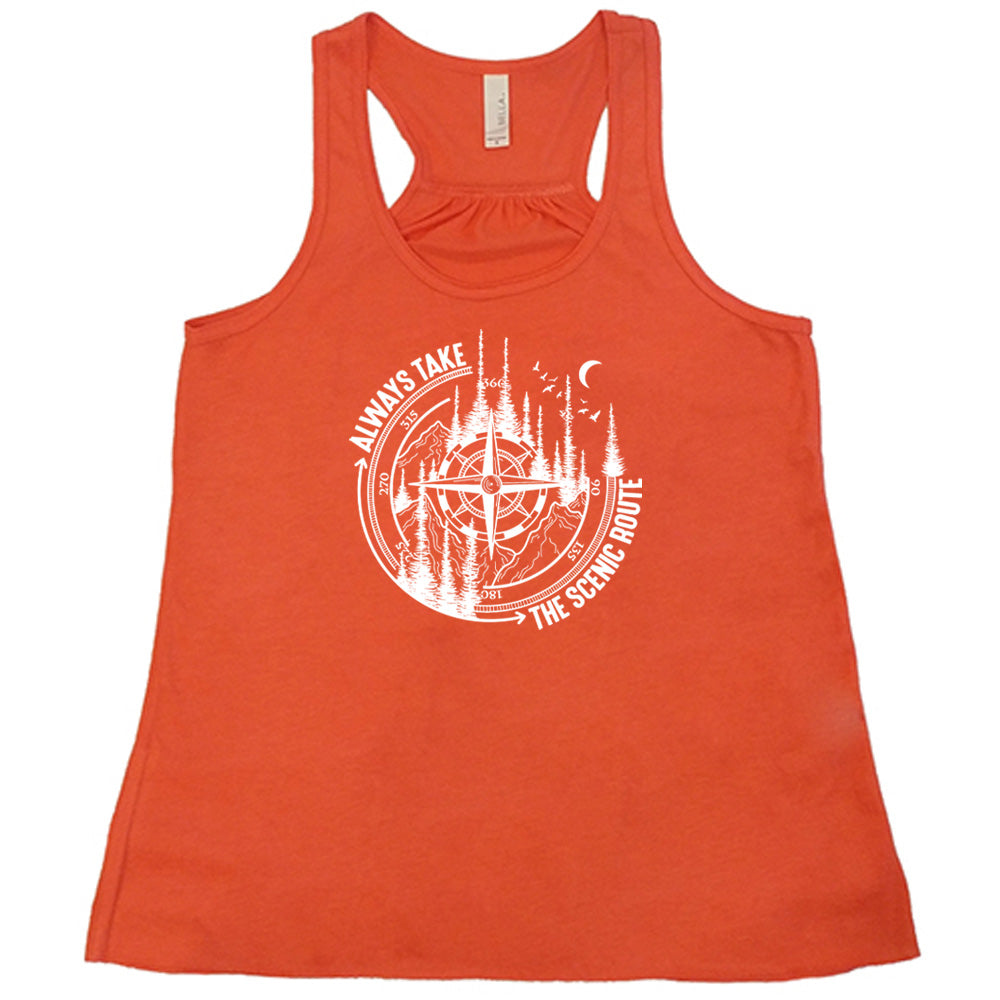 Coral colored flowy tank with a compass and forest graphic on it that says "Always Take The Scenic Route" 